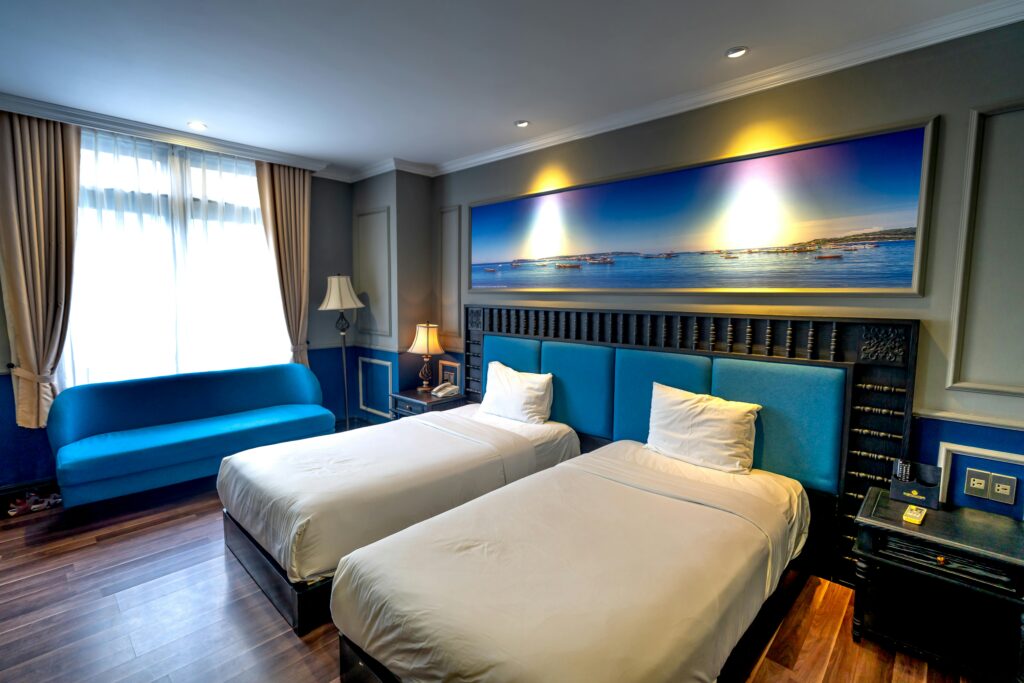 pexels photo 14021929 14021929 Luxurious hotel room features twin beds, modern decor, and ambient lighting.